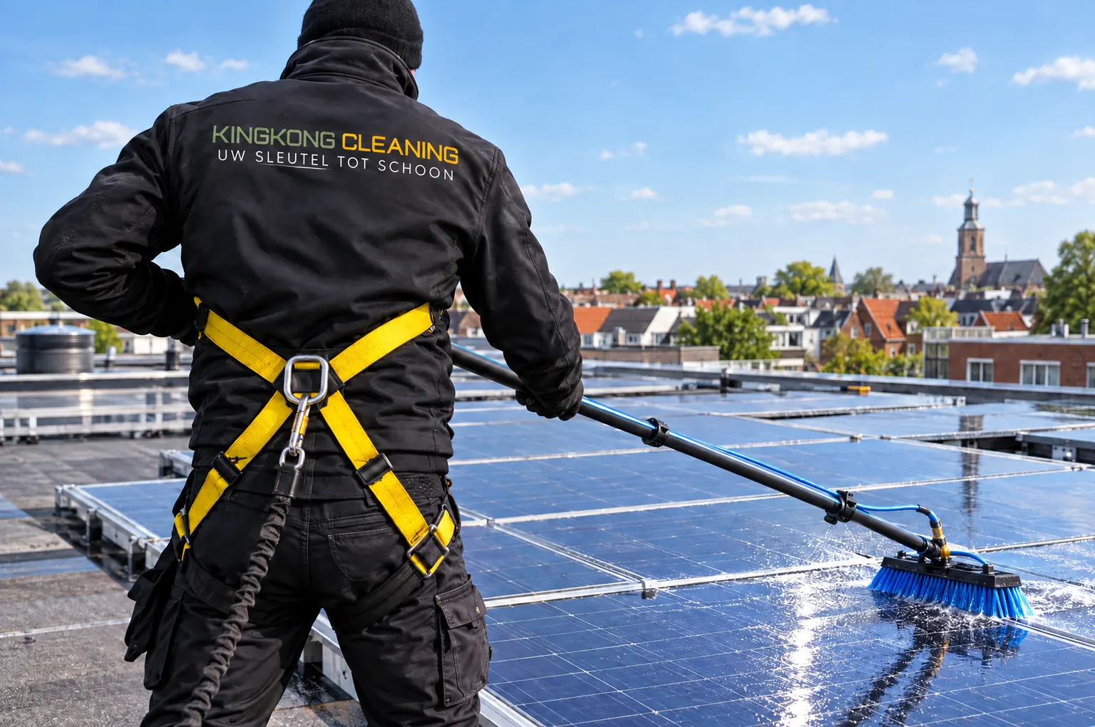 Medewerker van Kingkong Cleaning reinigt zonnepanelen op een dak